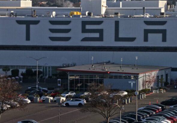 Aerial view of a Tesla factory showing the parking lot and exterior