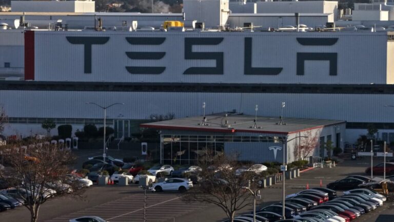 Aerial view of a Tesla factory showing the parking lot and exterior