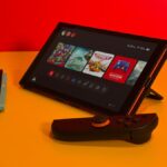 The Switch 2 standing up on a table with Joy-Cons detached.