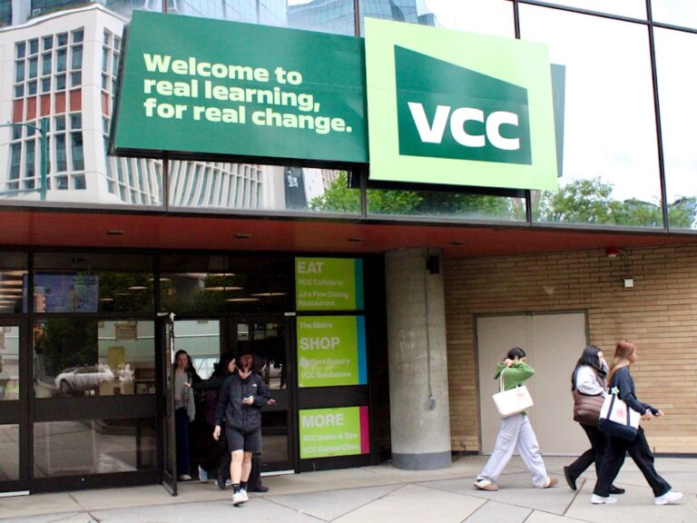 Students leave a glass community college building.