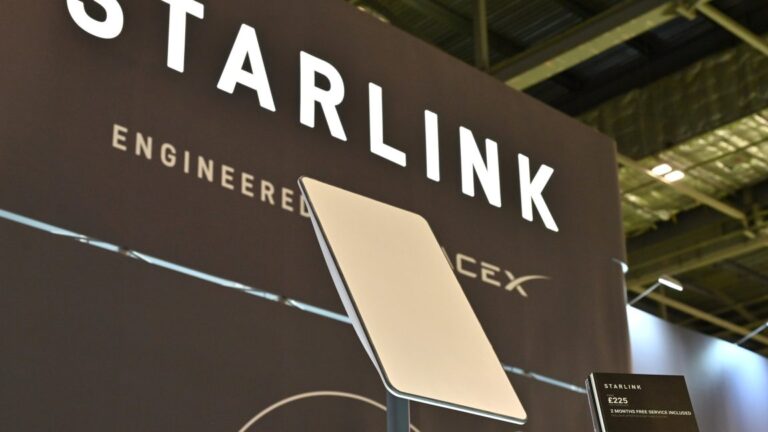 A Starlink terminal in front of a sign that says, "Starlink: Engineered by SpaceX."