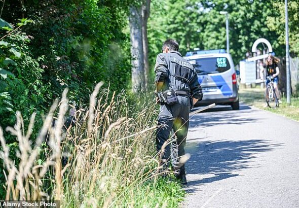 A three-month-old baby was snatched from a pram outside his home in Germany after his mother said she had briefly left him outside while carrying shopping up to her second-floor apartment. Pictured: Officers during the search