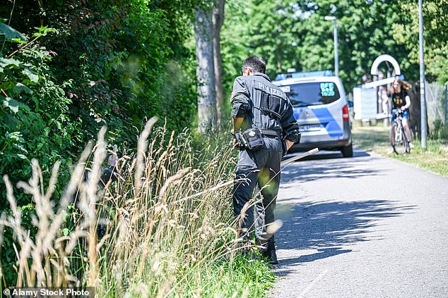 A three-month-old baby was snatched from a pram outside his home in Germany after his mother said she had briefly left him outside while carrying shopping up to her second-floor apartment. Pictured: Officers during the search
