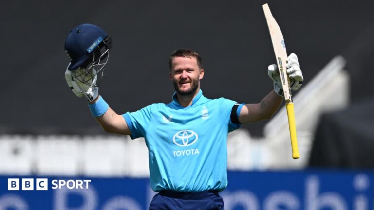 Ben Duckett raising his bat and helmet