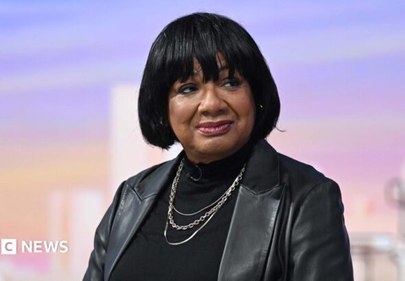 Diane Abbott sitting in the Sunday with Laura Kuenssberg TV studio, wearing a black leather jacket over a black top
