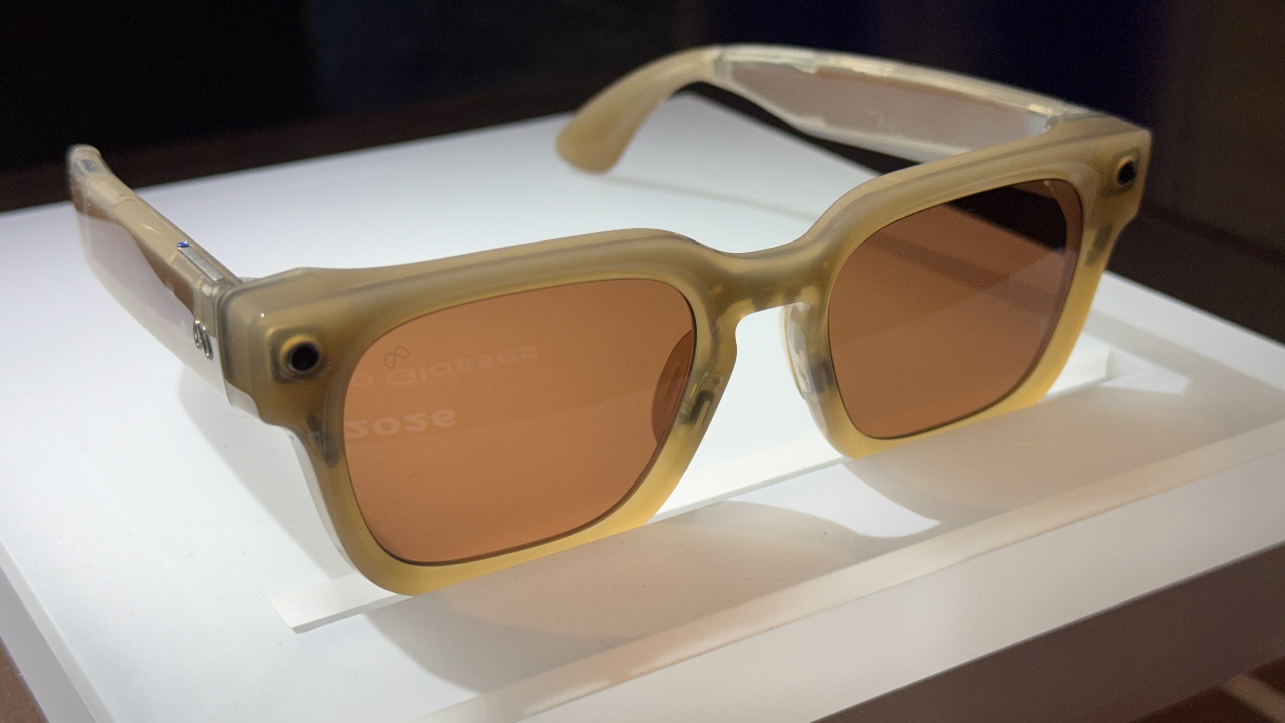 A pair of Meta smart glasses on a white pedestal