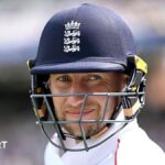 Joe Root smiles under his dark blue helmet