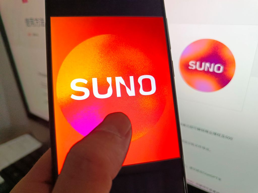 Suno's logo on a smartphone with Suno's logo in the background.