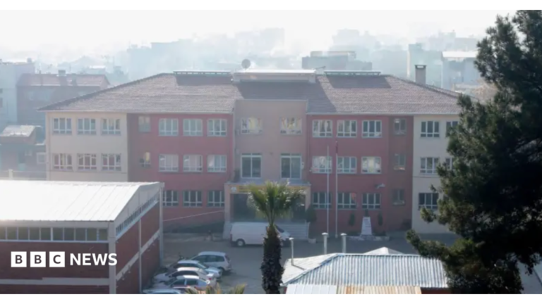 A photo of the school where the attack took place, taken in 2022 - it's a three story building that looks fairly modern but unremarkable - it has a mix of cream and red colouring and is seen from a middistance