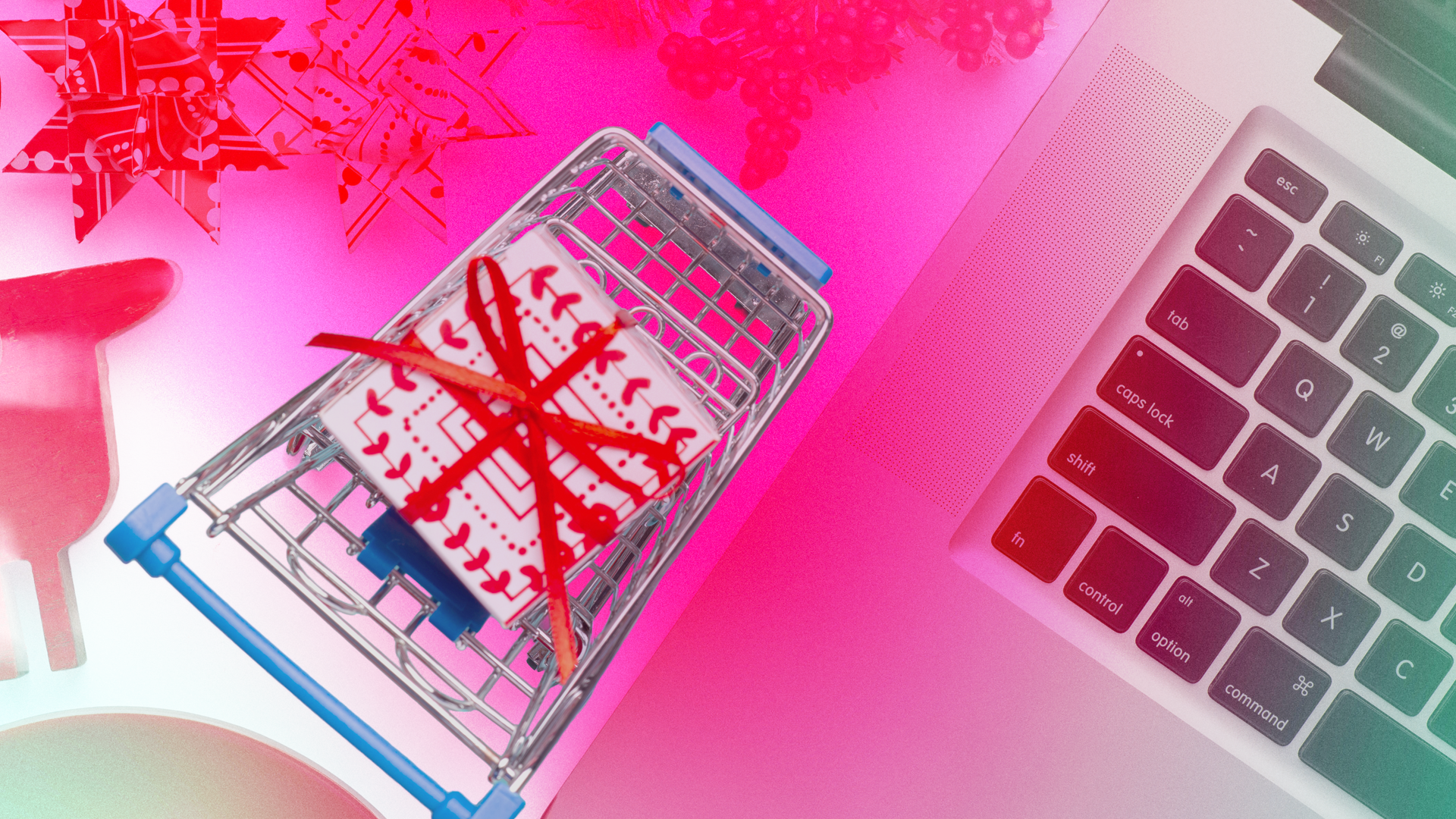 Shopping cart with a gift inside beside a MacBook keyboard