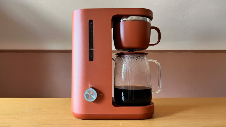 A clay-colored coffee pot sitting on a desk