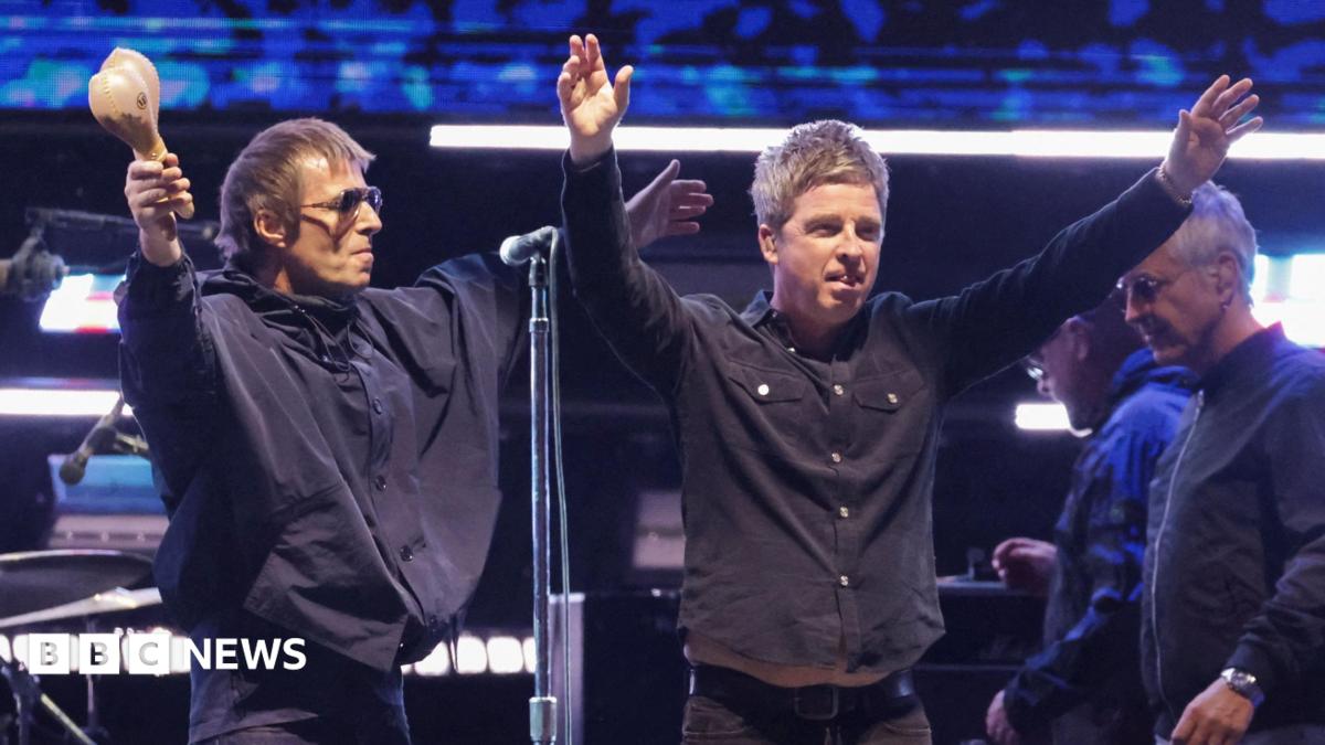 Liam and Noel Gallagher of Oasis with their arms outstretched accepting applause from the audience at the Rose Bowl Stadium in Pasadena, California in September 2025