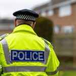 A stock image of a police officer with his back to the camera