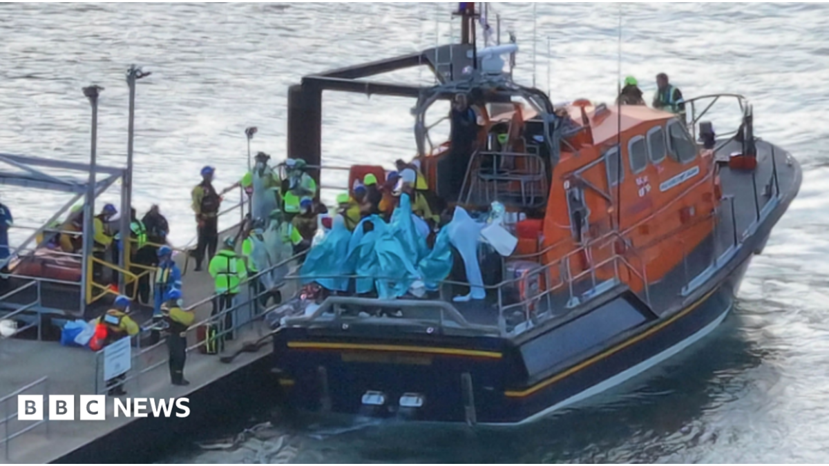 People wrapped in blankets on the back of an RNLI lifeboat moored by a pontoon at Eastney, Portsmouth, on 6.9.26