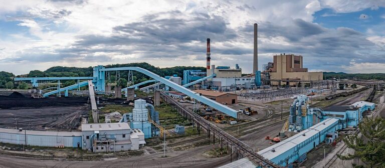 Image of a coal-fired power plant, showing lots of conveyor belts and a few smokestacks.