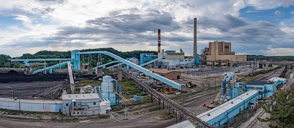 Image of a coal-fired power plant, showing lots of conveyor belts and a few smokestacks.