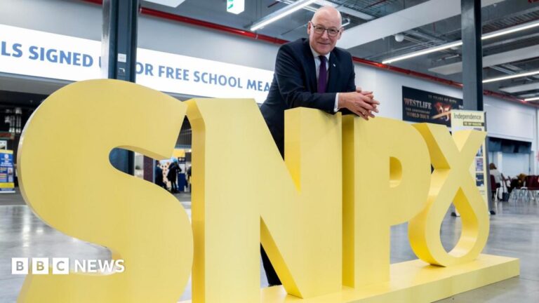 First Minister and party leader John Swinney poses for photographs alongside the party’s logo at the Scottish National Party (SNP) annual conference.