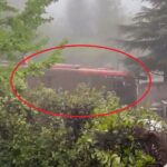 Harrowing moment bus is swept away by mud as terrified passengers cling to roof