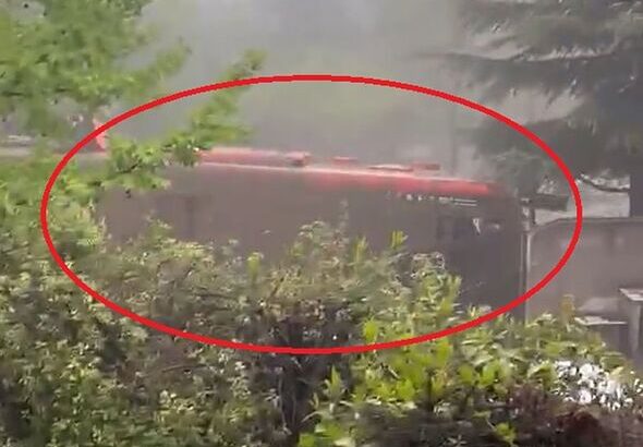 Harrowing moment bus is swept away by mud as terrified passengers cling to roof
