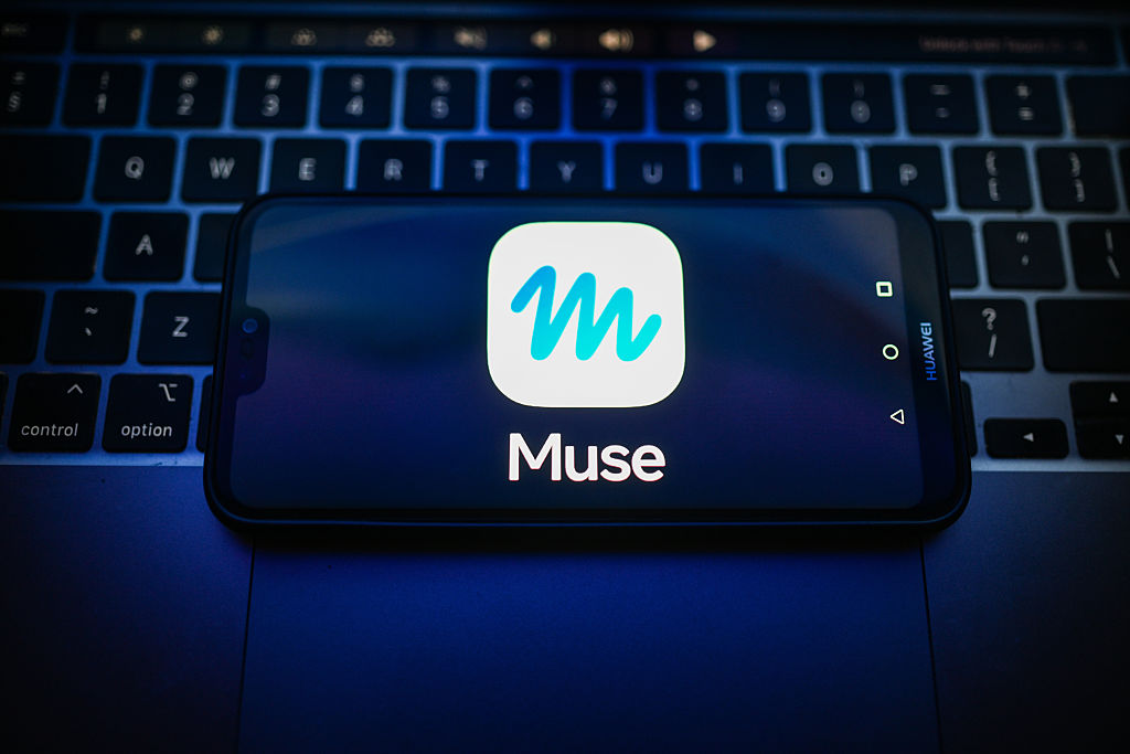 A photo of a Huawei phone showing the Meta Muse AI agent logo on top of a laptop keyboard